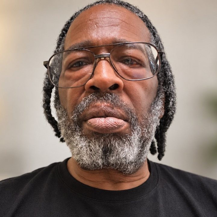 James E. King III, Secretary, wearing glasses and a black shirt.