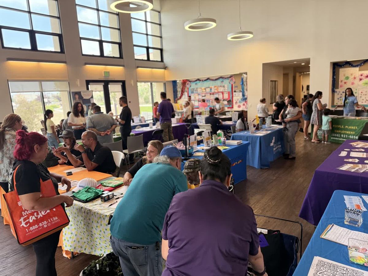 A CCE outreach table with a banner and printed resources at a community event.